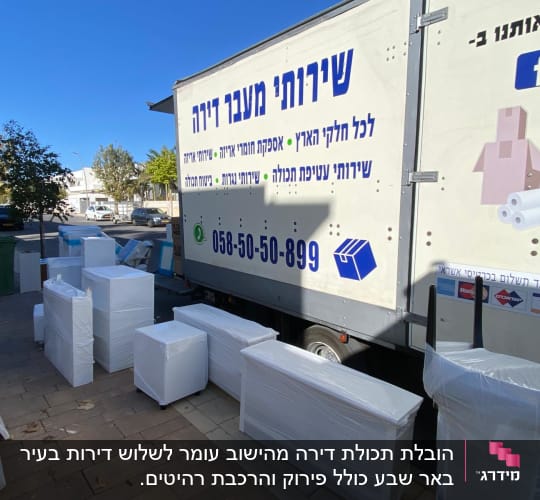 משאית הובלה עם רהיטים עטופים בניילון על המדרכה